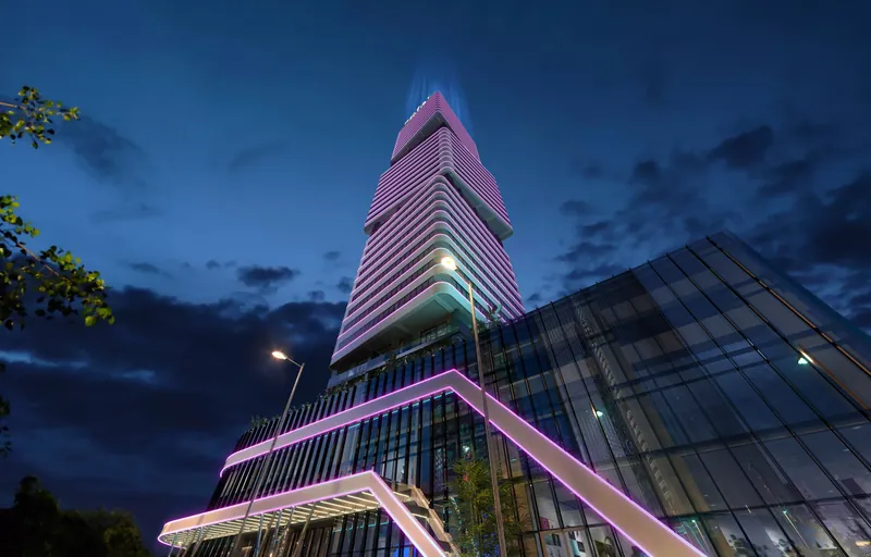 The tower and podium lit at night — Cube Metropol, Batumi