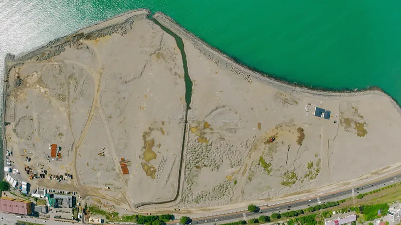 Reclaimed island site, top-down drone view — Tonino Lamborghini Tower, Batumi