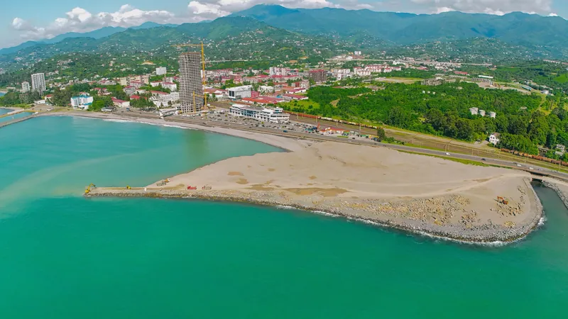Reclaimed island site with the city behind, drone view — Tonino Lamborghini Tower, Batumi