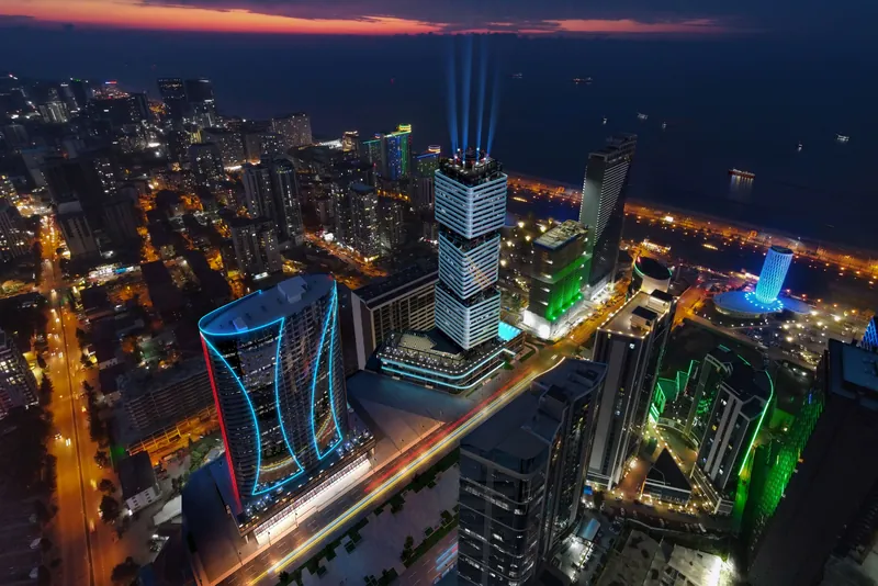 Aerial view of the tower in the city at night — Ovale Metropol, Batumi